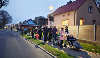 Festliche Atmosphäre beim Laternenumzug der ProCurand Seniorenresidenz Am Görnsee: Teilnehmer ziehen mit selbstgebastelten Laternen durch den Ort, begleitet von Musik und guter Stimmung.