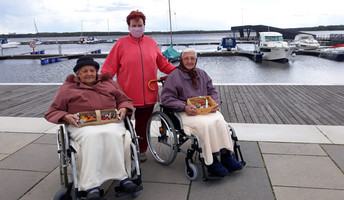 Zwei Seniorinnen bringen selbst bemalte Steine zur Seeschlange