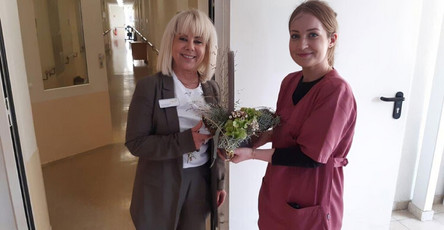 Francie Brähmig, die erste erfolgreiche Absolventin des APH-Kurses in der ProCurand Seniorenresidenz Sanft am See, erhält stolz einen Blumenstrauß zur Feier ihres bestandenen Kurses. 