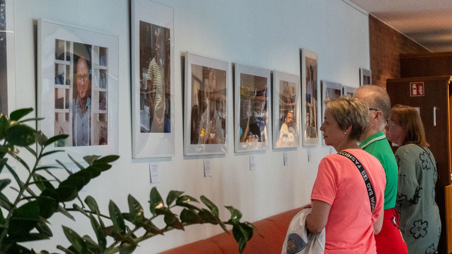 Besucher*innen betrachten gemeinsam die eindrucksvollen Bilder der Ausstellung „Friedrichshagener Kaleidoskop“ im Restaurant Vier Jahreszeiten der ProCurand Seniorenresidenz. Der Austausch über die Kunstwerke schafft eine anregende Atmosphäre.