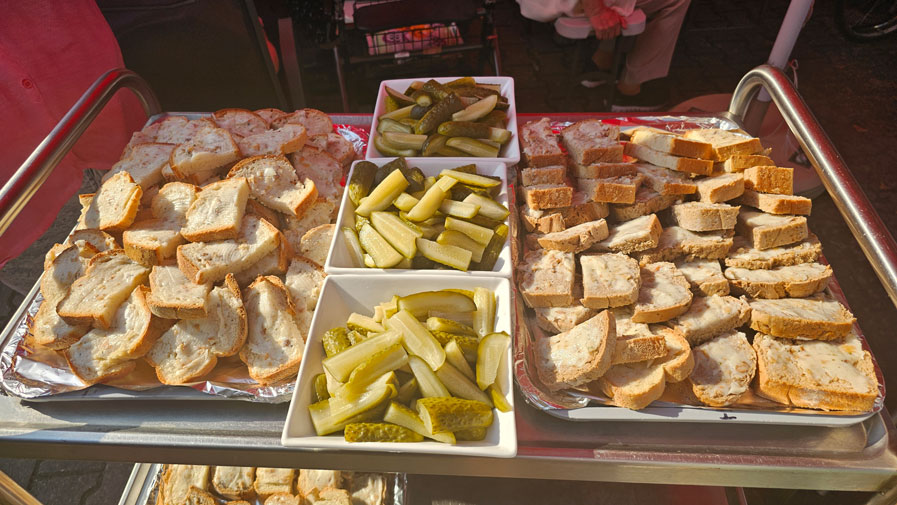 Ein Tisch voller köstlicher Schmalzstullen und frischer Gurken wartet darauf, serviert zu werden. Die leckeren Snacks sind das Highlight des Backofenfests in der ProCurand Seniorenresidenz Am Görnsee!