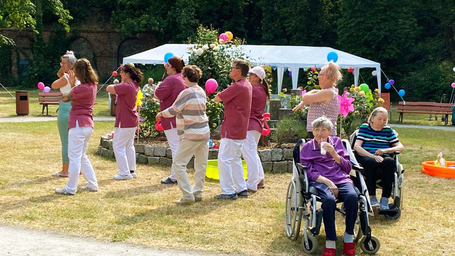 Am Sommerfest der ProCurand Seniorenresidenz Am Krökentor tanzen die Mitarbeiter*innen den Macarena.