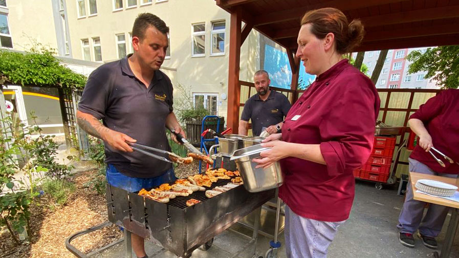 Für das Sommerfest der ProCurand Seniorenresidenz Am Krökentor versorgt das Team alle Anwesenden mit leckerem Grillgut.